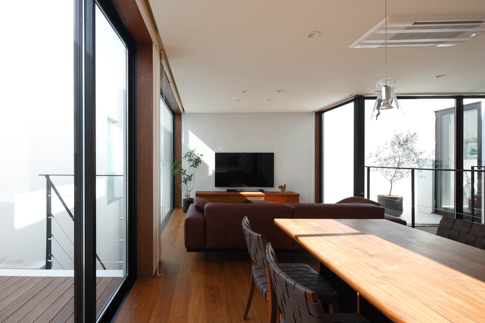 Modelo de salón abierto minimalista grande con paredes multicolor, suelo de madera oscura y suelo marrón