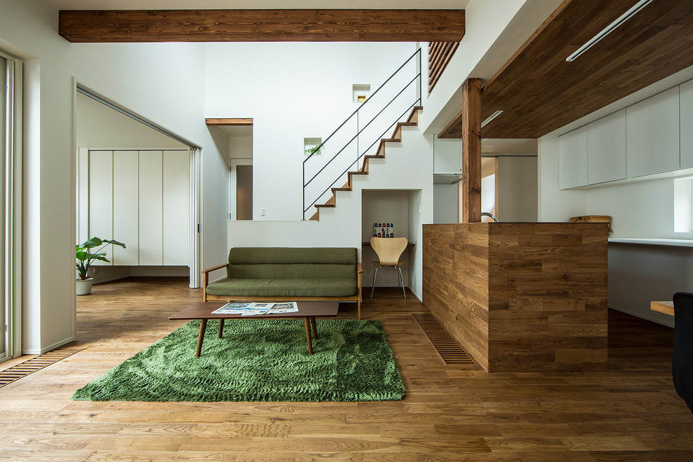 Immagine di un soggiorno etnico con pavimento in legno massello medio, nessun camino, pareti bianche e nessuna TV