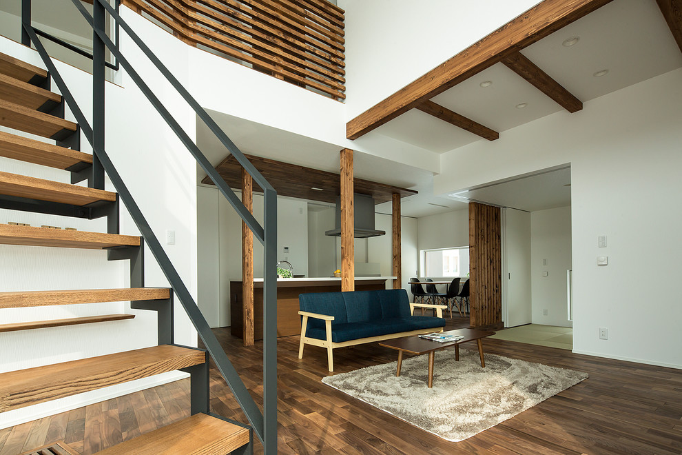 Ejemplo de salón abierto asiático de tamaño medio sin chimenea con paredes blancas, suelo de madera en tonos medios y televisor independiente