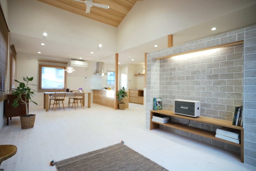 Cette photo montre un salon scandinave ouvert avec un mur blanc, parquet clair, aucune cheminée, un téléviseur indépendant et un sol blanc.