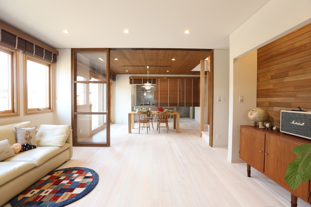 Immagine di un soggiorno nordico aperto con pareti bianche, parquet chiaro, TV autoportante e pavimento beige