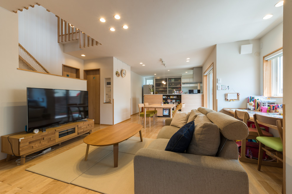 Idee per un soggiorno minimalista aperto con pareti bianche, parquet chiaro, TV autoportante e pavimento marrone