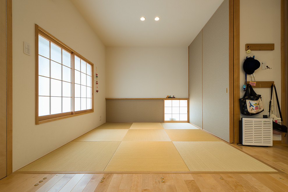 Cette photo montre un salon asiatique avec un mur blanc, un sol de tatami et un sol marron.