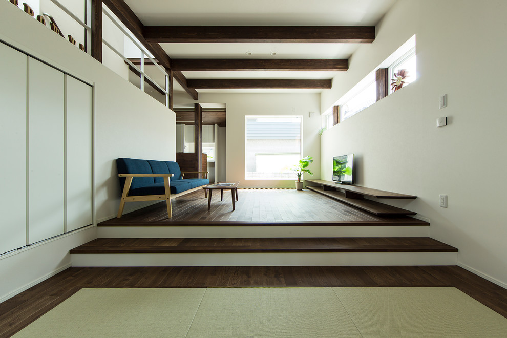 Ejemplo de salón de estilo zen con paredes blancas, suelo de madera oscura y suelo marrón
