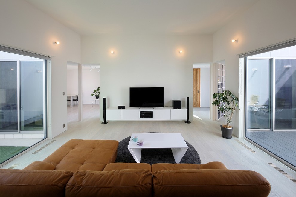 Foto di un soggiorno minimalista aperto con pareti bianche, pavimento in compensato, TV autoportante e pavimento bianco