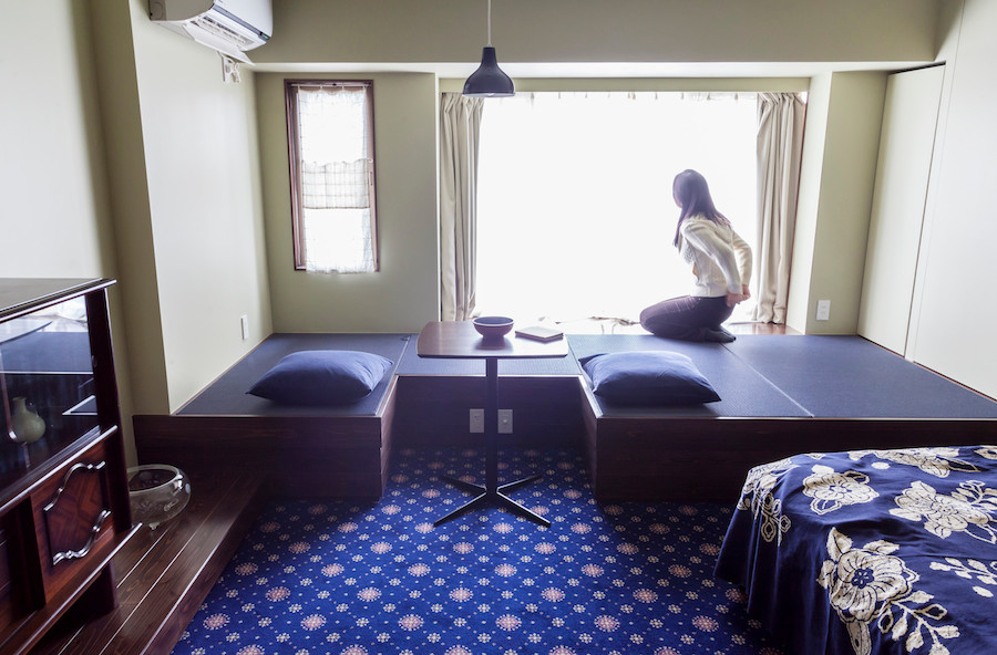 Cette image montre un petit salon asiatique ouvert avec une salle de réception, un téléviseur fixé au mur, un mur blanc et aucune cheminée.