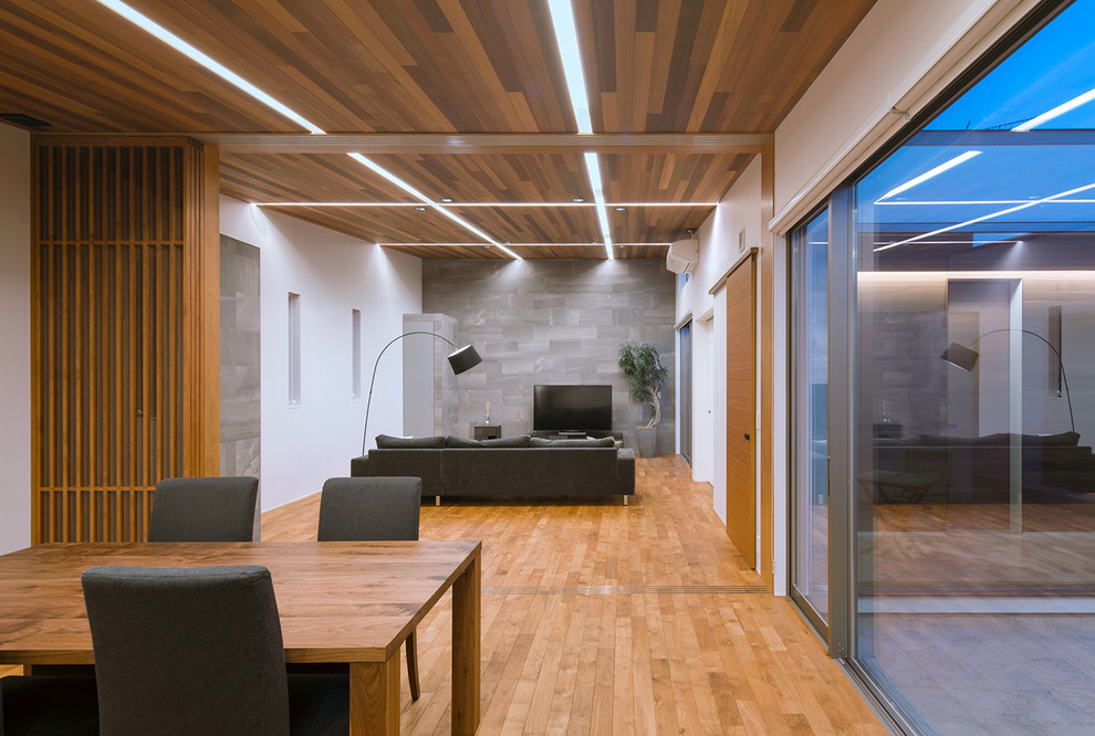 Idee per un soggiorno moderno aperto con pareti bianche, pavimento in legno massello medio, TV autoportante e pavimento marrone