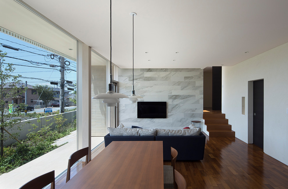 Foto di un soggiorno moderno di medie dimensioni e aperto con pareti bianche, parquet scuro, nessun camino, TV a parete e pavimento marrone