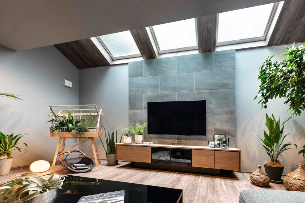 Inredning av ett modernt mellanstort allrum med öppen planlösning, med en hemmabar, plywoodgolv, en väggmonterad TV, brunt golv och bruna väggar