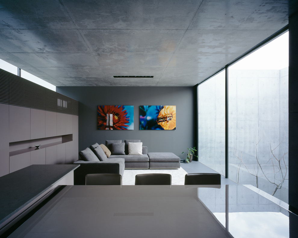 Imagen de salón abierto contemporáneo con paredes grises
