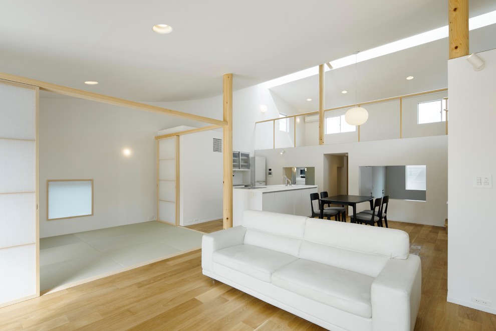 Idée de décoration pour un salon design ouvert avec un mur blanc, parquet clair, aucune cheminée et aucun téléviseur.