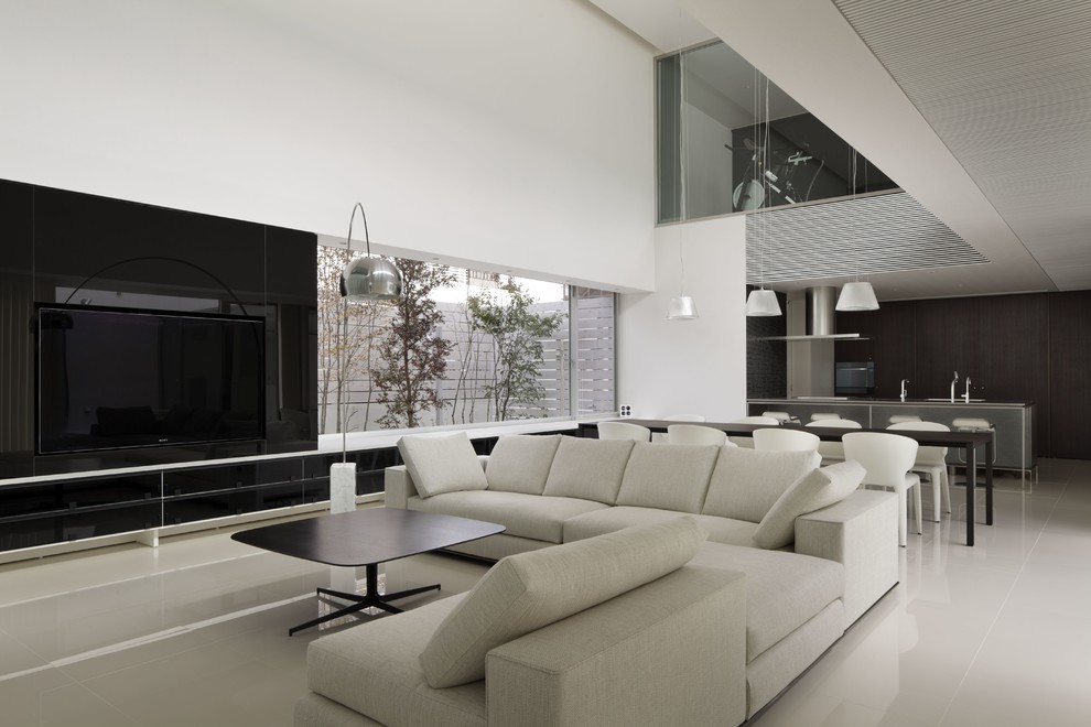 Cette image montre un grand salon minimaliste ouvert avec une salle de réception, un mur blanc, aucune cheminée et un téléviseur encastré.