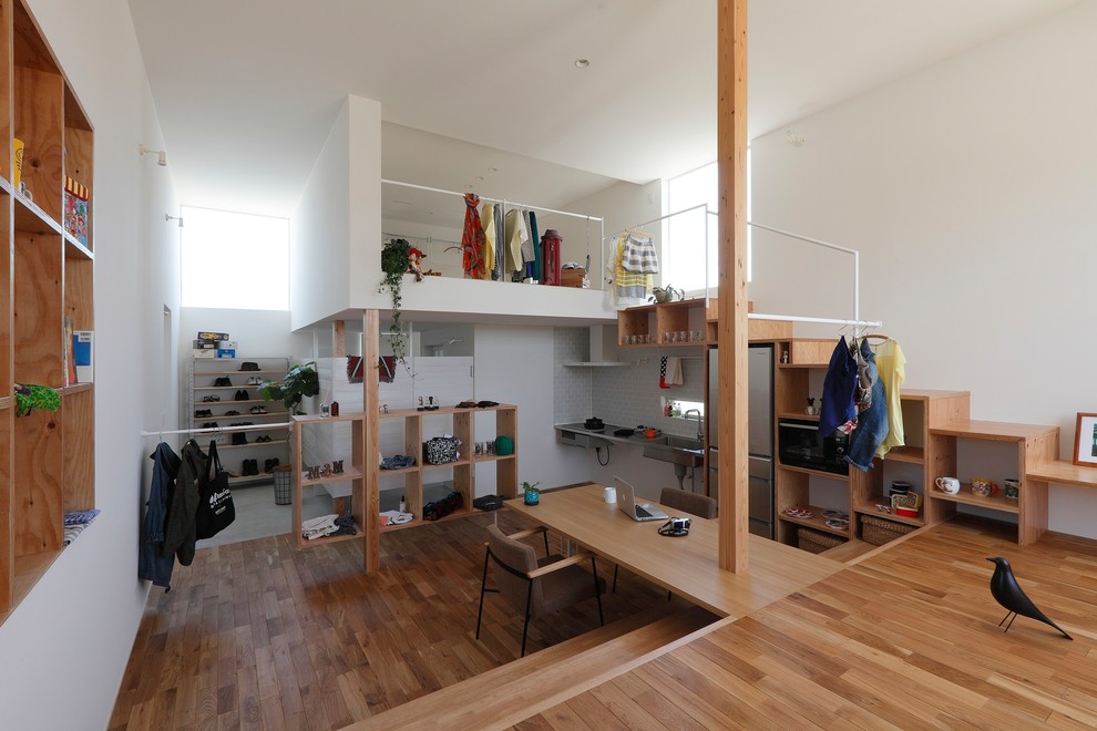 Kleines, Offenes Maritimes Wohnzimmer mit weißer Wandfarbe, braunem Holzboden, freistehendem TV und braunem Boden in Sonstige