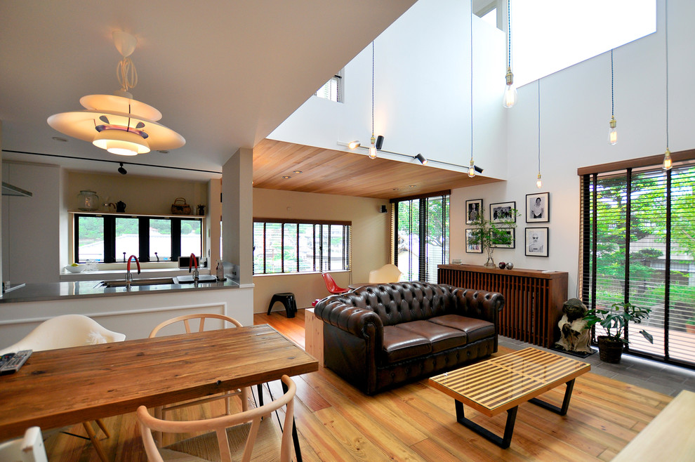 Esempio di un soggiorno minimalista con pareti bianche, pavimento in legno massello medio e pavimento marrone