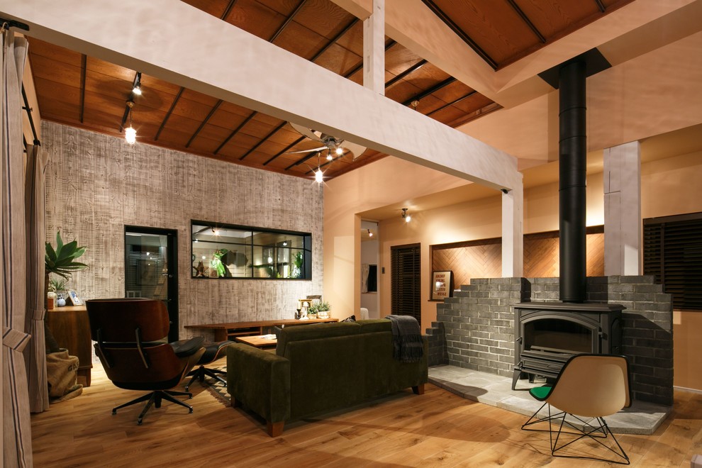 Foto de salón de estilo zen con suelo de madera en tonos medios, estufa de leña y marco de chimenea de piedra
