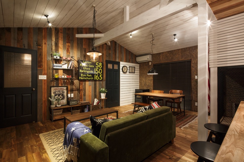 Ejemplo de salón industrial con paredes marrones, suelo de madera en tonos medios y suelo marrón