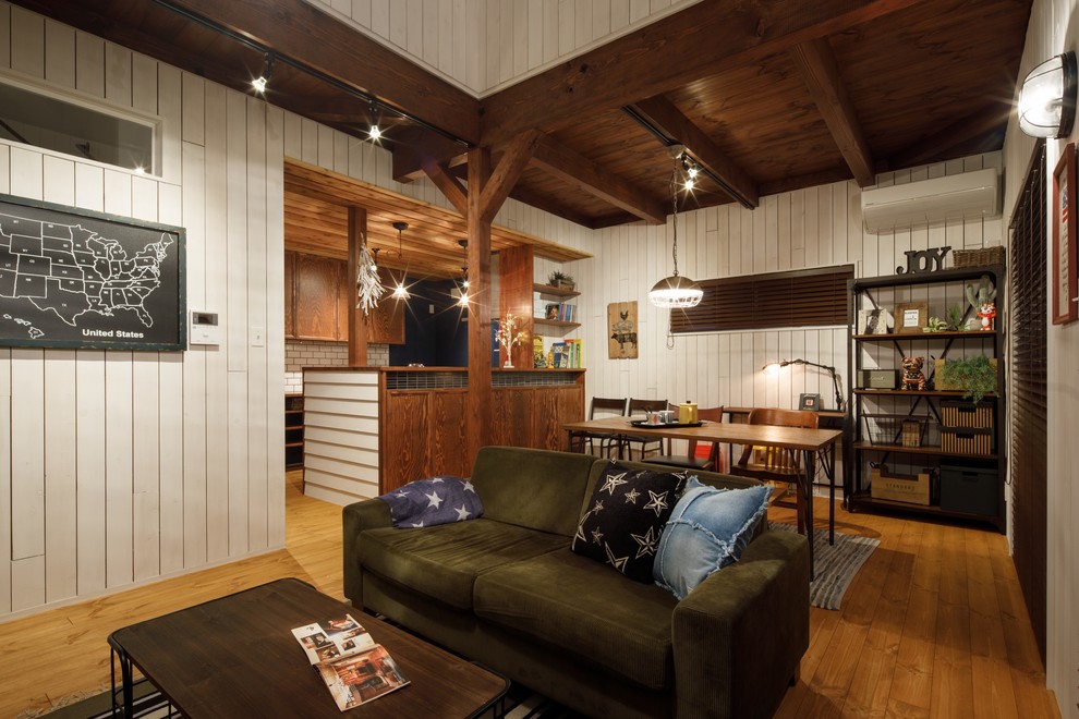 Foto di un soggiorno etnico con pareti bianche, pavimento in legno massello medio e pavimento marrone