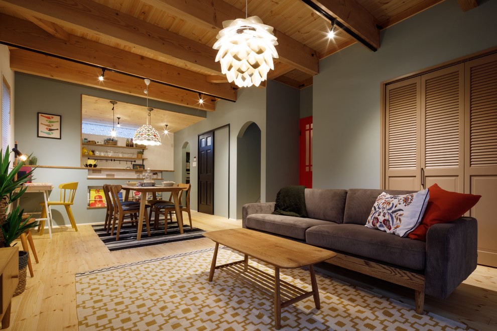 Diseño de salón abierto escandinavo con paredes azules, suelo de madera clara y suelo beige