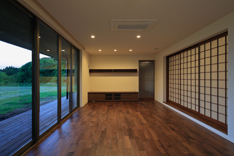 Ejemplo de salón abierto de estilo zen con paredes blancas y suelo marrón