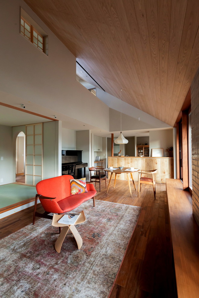 Идея дизайна: открытая гостиная комната в восточном стиле с паркетным полом среднего тона и белыми стенами без камина, телевизора