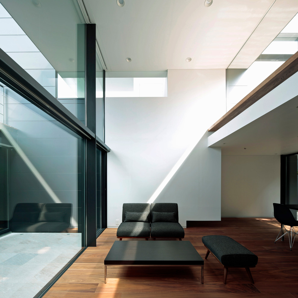 На фото: гостиная комната в стиле модернизм с белыми стенами, паркетным полом среднего тона и коричневым полом с
