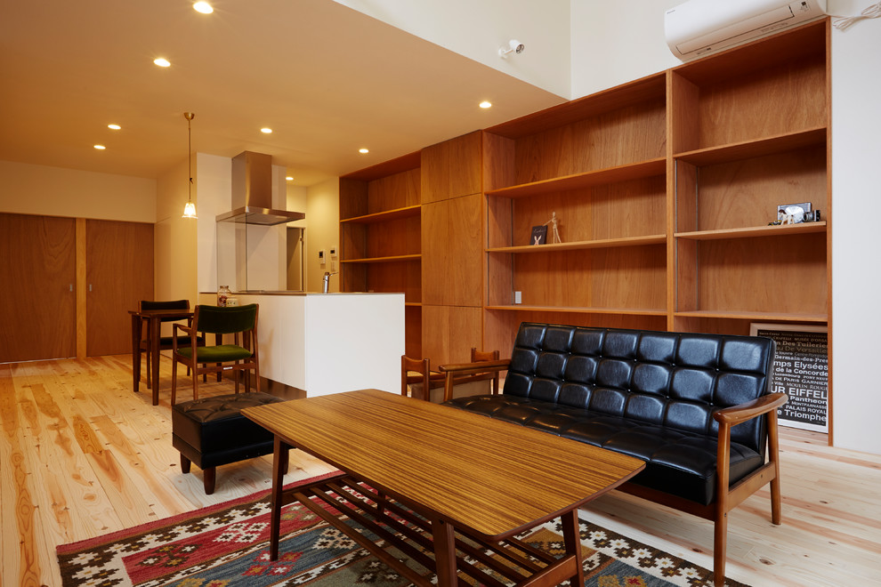 Ejemplo de salón abierto asiático pequeño con suelo de madera clara, paredes marrones, televisor independiente y suelo beige
