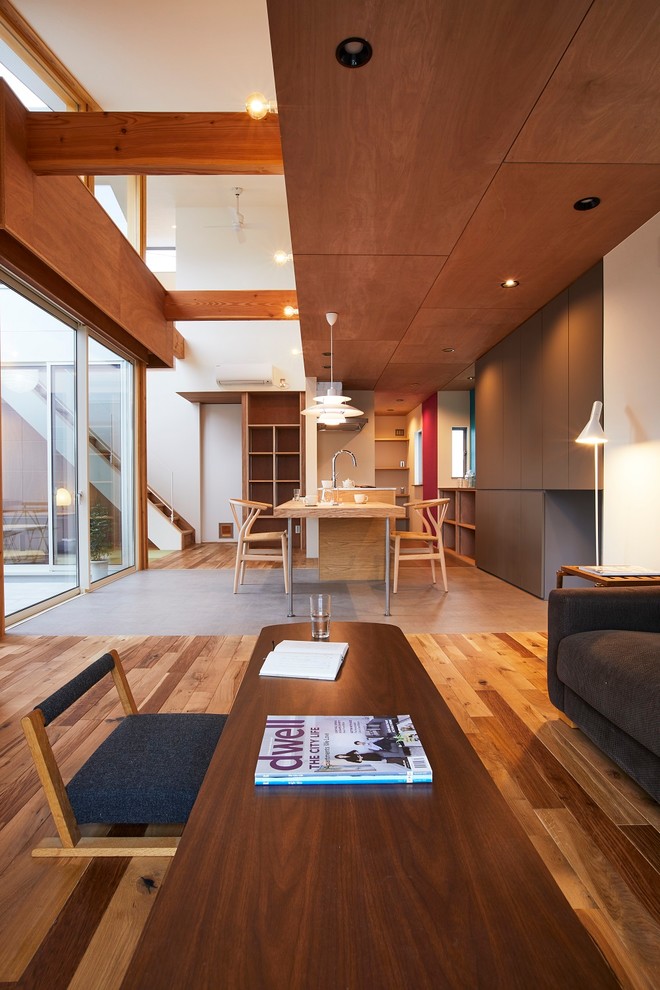 Esempio di un soggiorno moderno di medie dimensioni e aperto con pareti marroni, pavimento in legno massello medio, nessun camino, TV autoportante e pavimento marrone