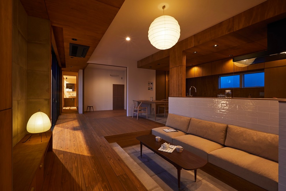 Ejemplo de salón abierto moderno de tamaño medio sin chimenea con paredes marrones, suelo de madera oscura, televisor independiente y suelo marrón