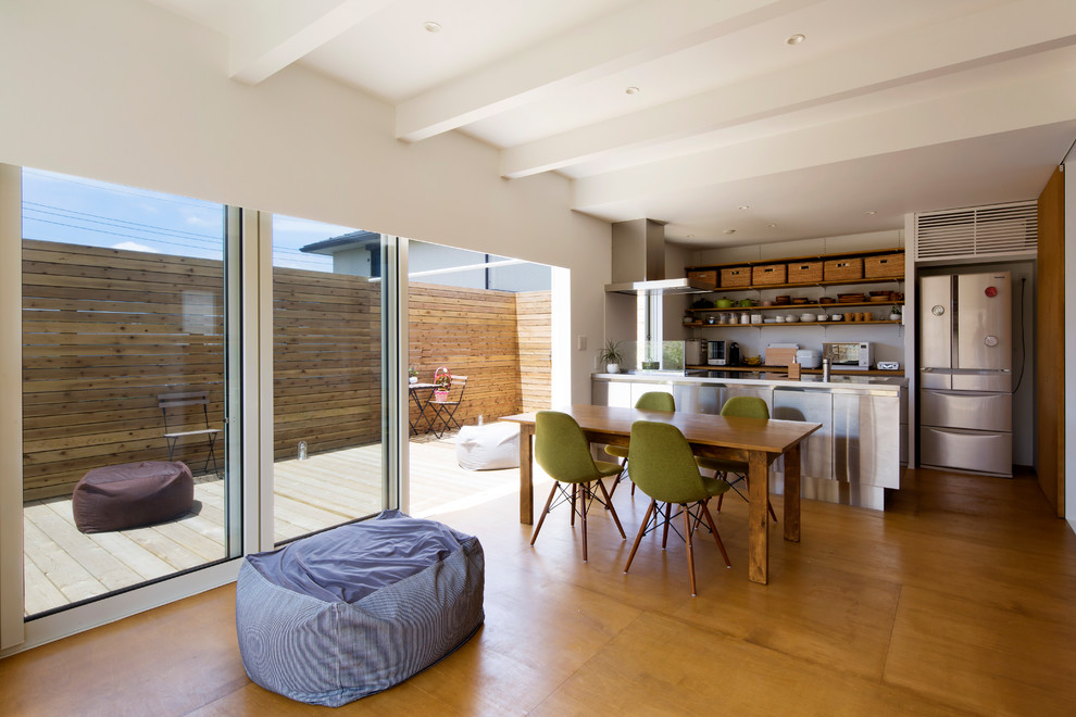 Aménagement d'un salon moderne ouvert avec un mur blanc, un sol en bois brun et un sol marron.