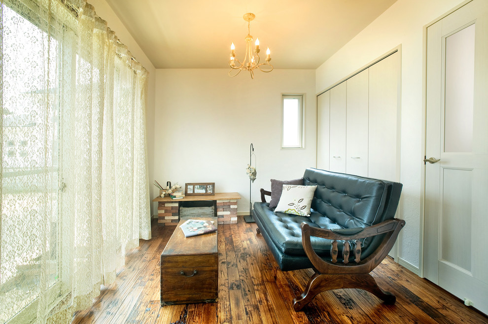 Imagen de salón campestre con paredes blancas, suelo de madera en tonos medios y suelo marrón