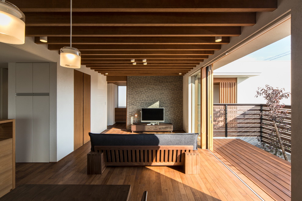 Modelo de salón abierto escandinavo con paredes blancas, suelo de madera en tonos medios y televisor independiente