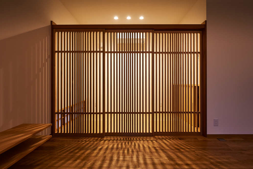 Ejemplo de salón abierto de estilo zen sin chimenea con paredes blancas, suelo de madera en tonos medios y televisor independiente