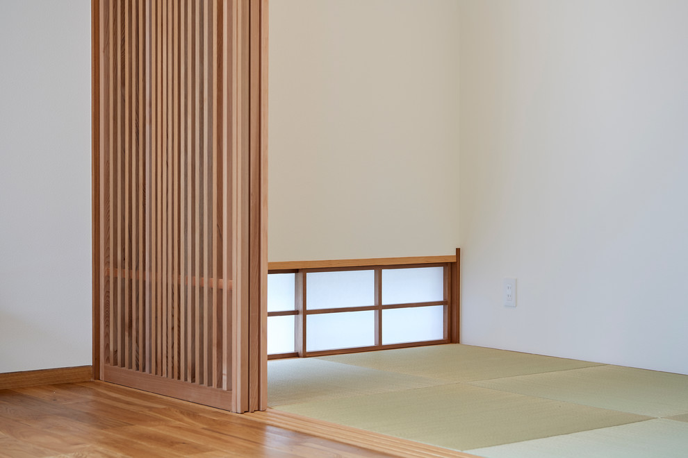 Offenes Asiatisches Wohnzimmer ohne Kamin mit weißer Wandfarbe und braunem Holzboden in Sonstige