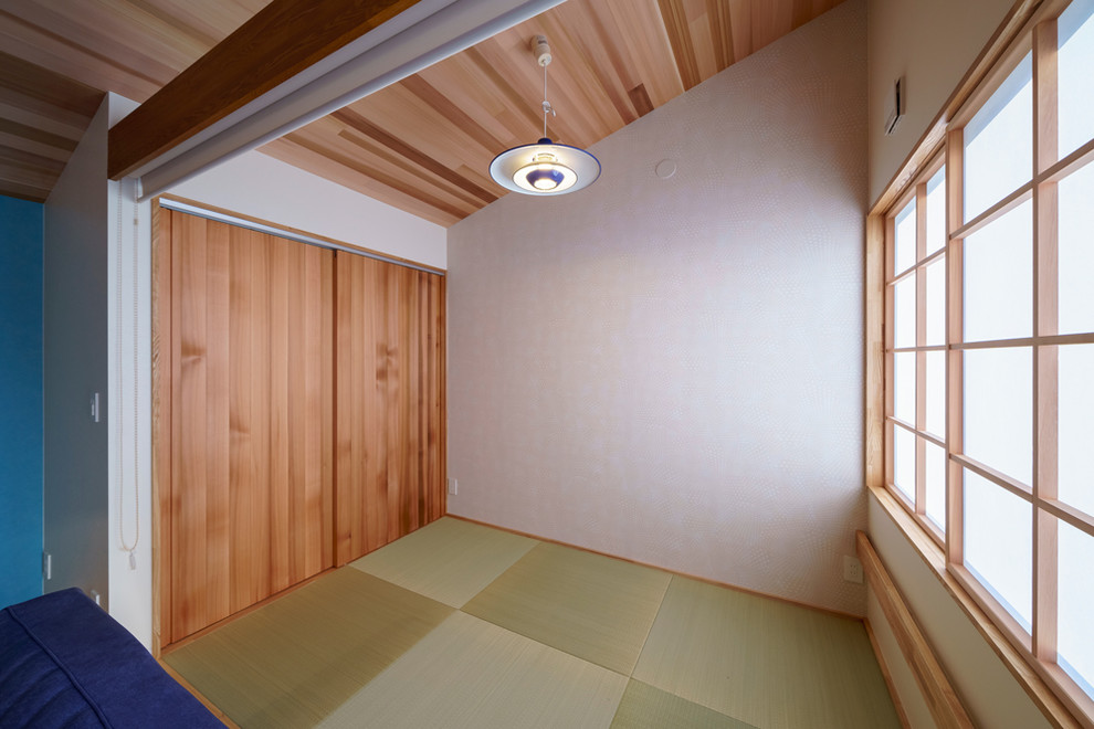 Modelo de salón abierto nórdico pequeño sin televisor con paredes blancas, tatami y suelo verde