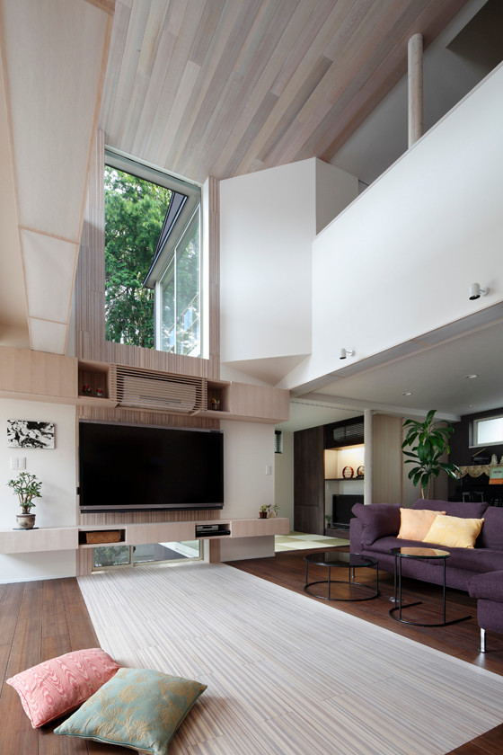 На фото: большая парадная, открытая гостиная комната в стиле шебби-шик с полом из бамбука, телевизором на стене и белым полом