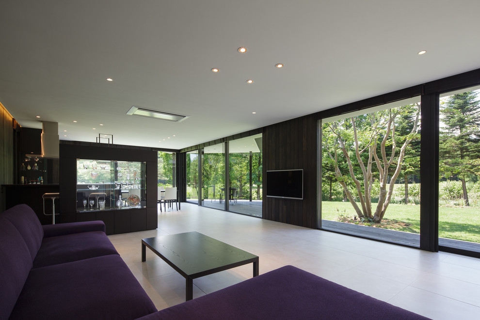 Immagine di un soggiorno minimalista con pareti marroni e TV a parete