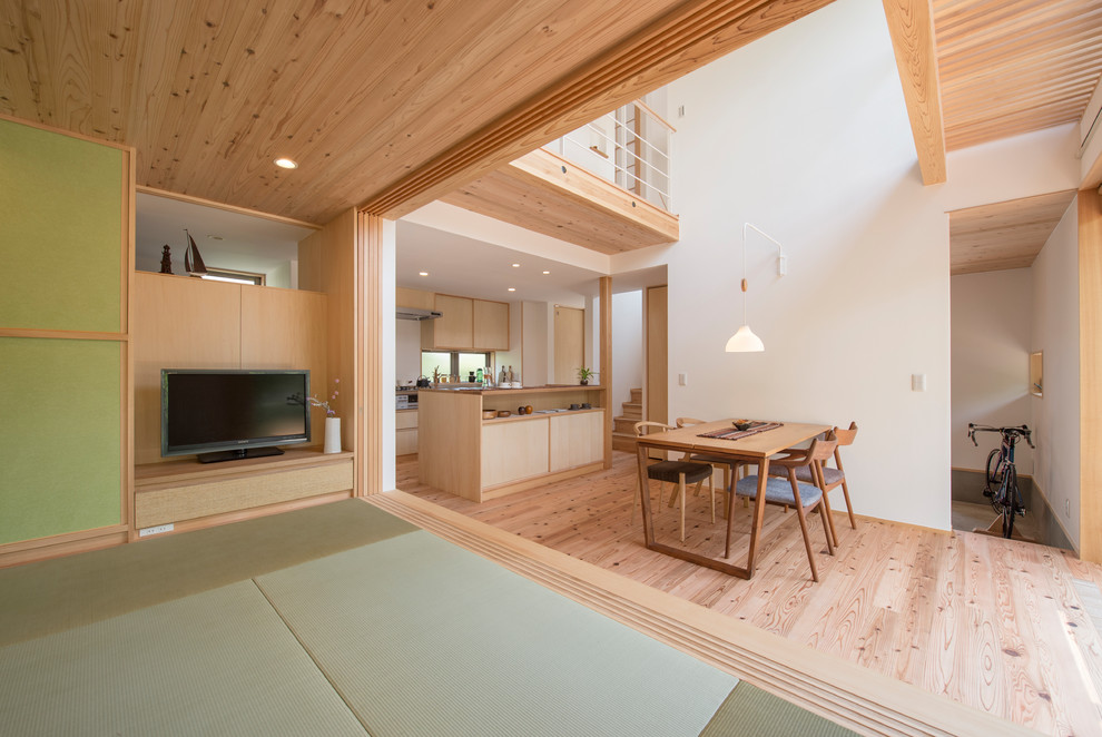 Идея дизайна: гостиная комната в восточном стиле с белыми стенами, татами, отдельно стоящим телевизором и зеленым полом