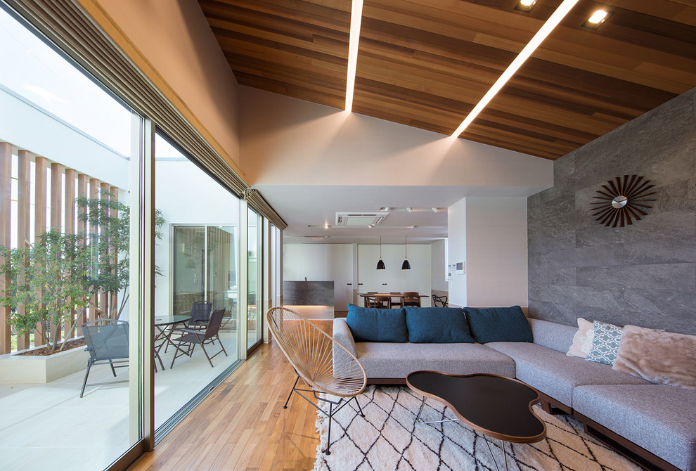 Foto di un soggiorno moderno aperto con pareti multicolore, pavimento in legno massello medio e pavimento marrone