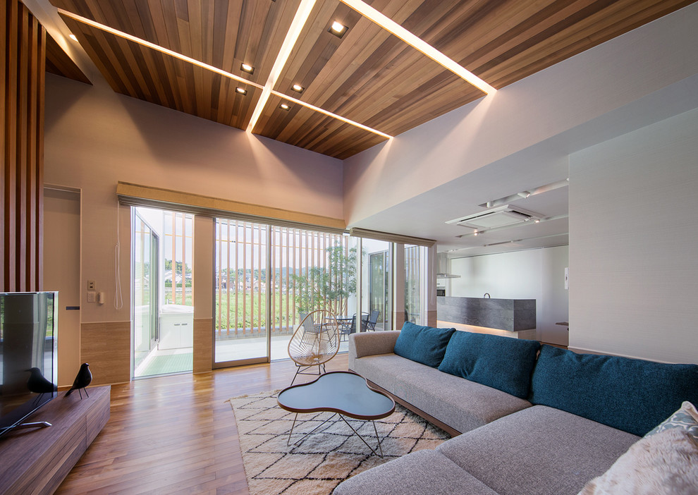 Ispirazione per un soggiorno moderno aperto con pareti multicolore, pavimento in legno massello medio e pavimento marrone