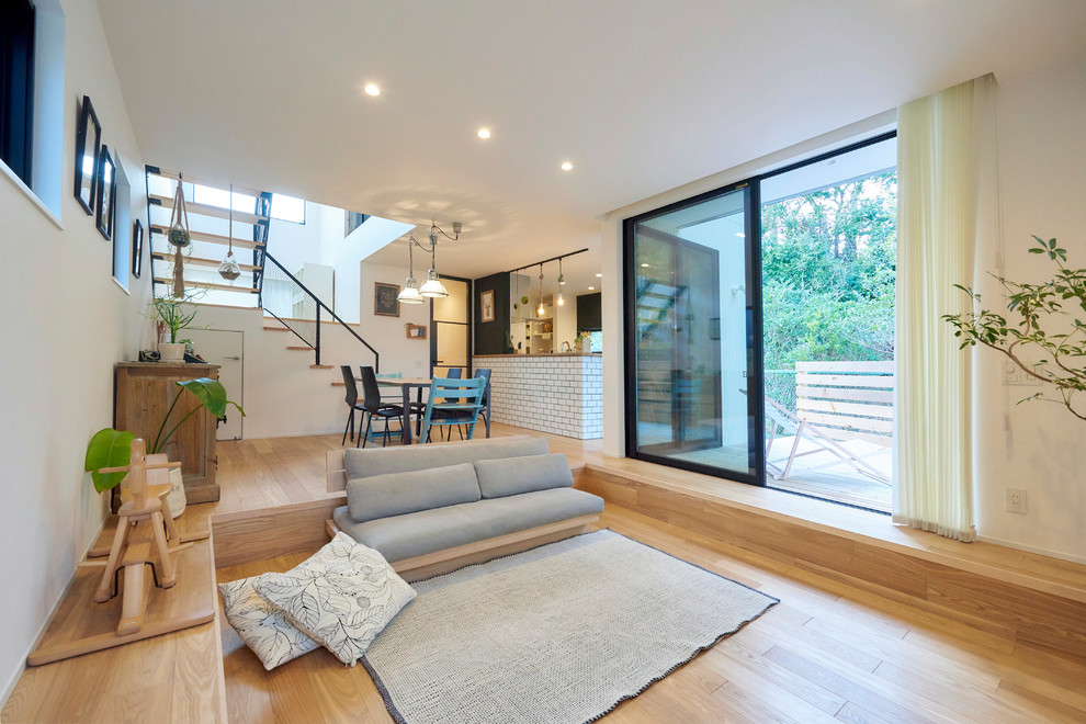 Industrial Wohnzimmer mit weißer Wandfarbe, hellem Holzboden und braunem Boden in Sonstige