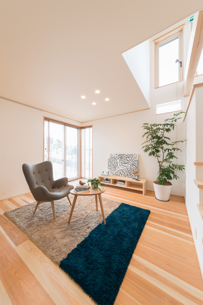 Asiatisches Wohnzimmer mit hellem Holzboden und braunem Boden in Sonstige