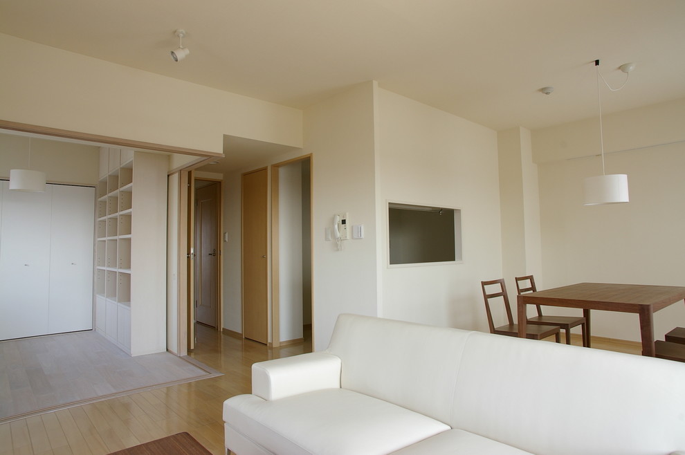 Diseño de salón abierto escandinavo de tamaño medio sin chimenea con paredes blancas, suelo marrón y suelo de contrachapado