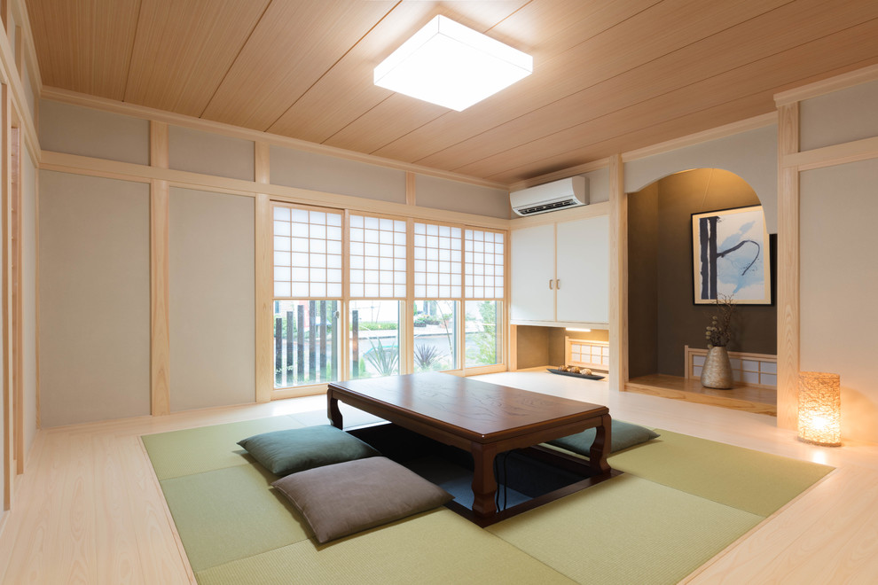 Asiatisches Wohnzimmer mit grauer Wandfarbe, hellem Holzboden und braunem Boden in Sonstige