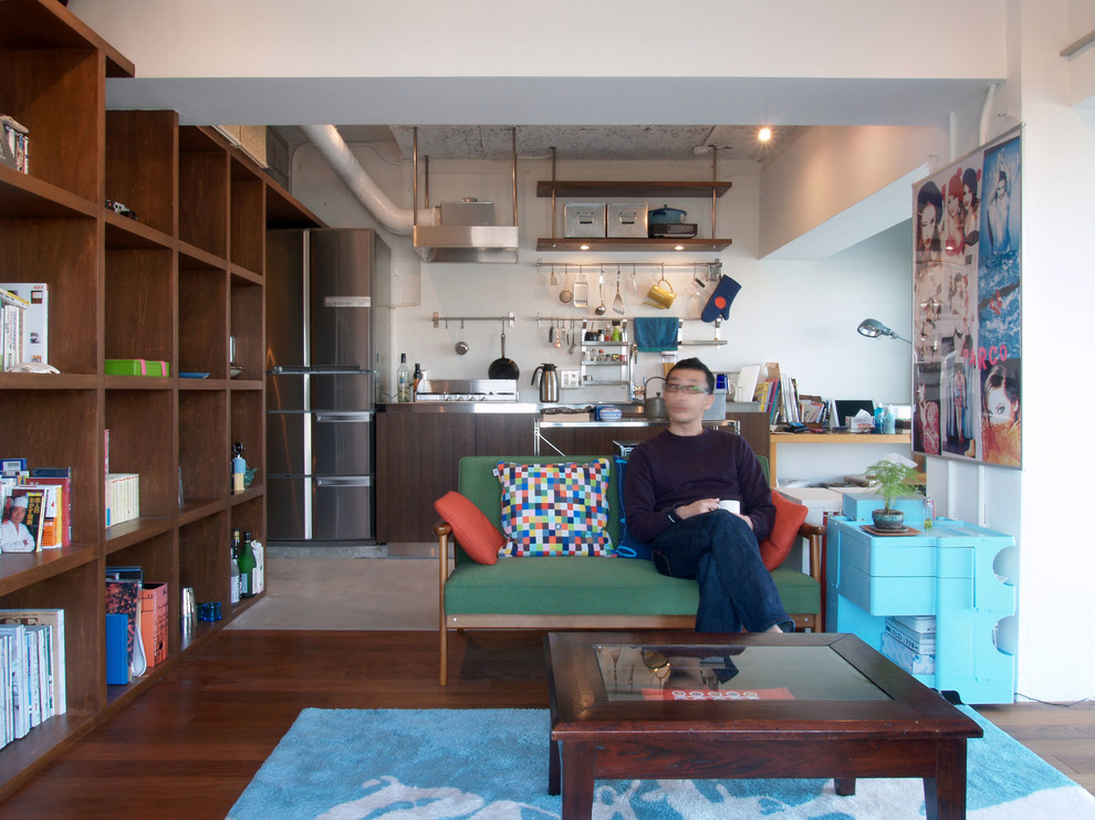This is an example of a small urban open plan living room in Tokyo with a reading nook, white walls, medium hardwood flooring, no fireplace and no tv.