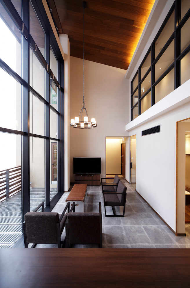 Inspiration för moderna vardagsrum, med vita väggar, betonggolv, en fristående TV och grått golv