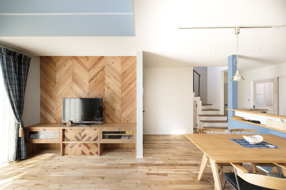 Imagen de salón abierto de estilo zen sin chimenea con paredes blancas, suelo de madera en tonos medios, televisor independiente y suelo marrón