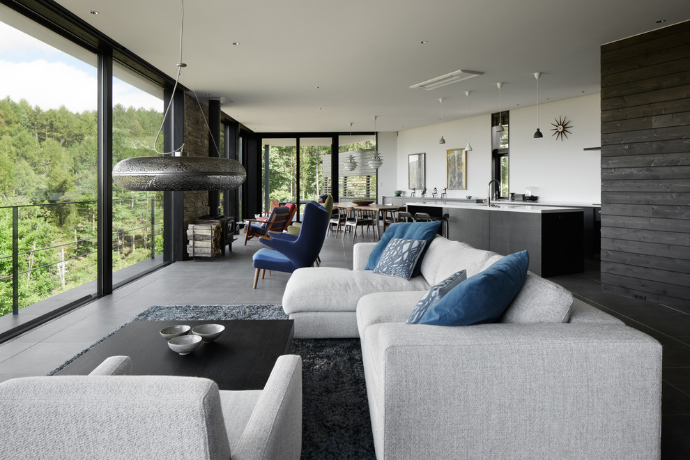 Идея дизайна: открытая гостиная комната в стиле модернизм с белыми стенами и серым полом