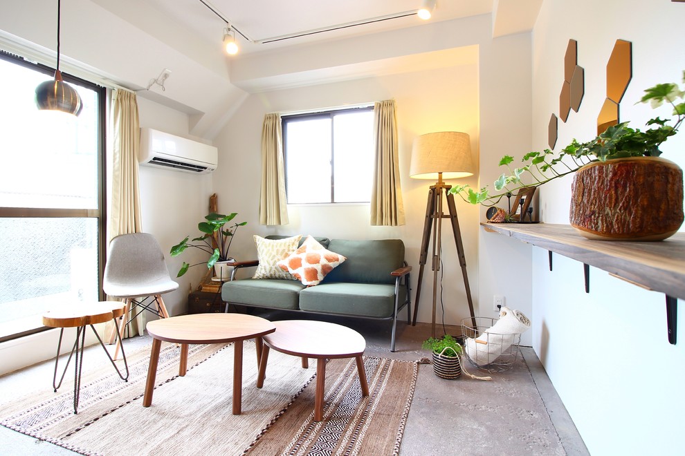 Cette image montre un petit salon minimaliste avec un mur blanc, sol en béton ciré et un sol gris.
