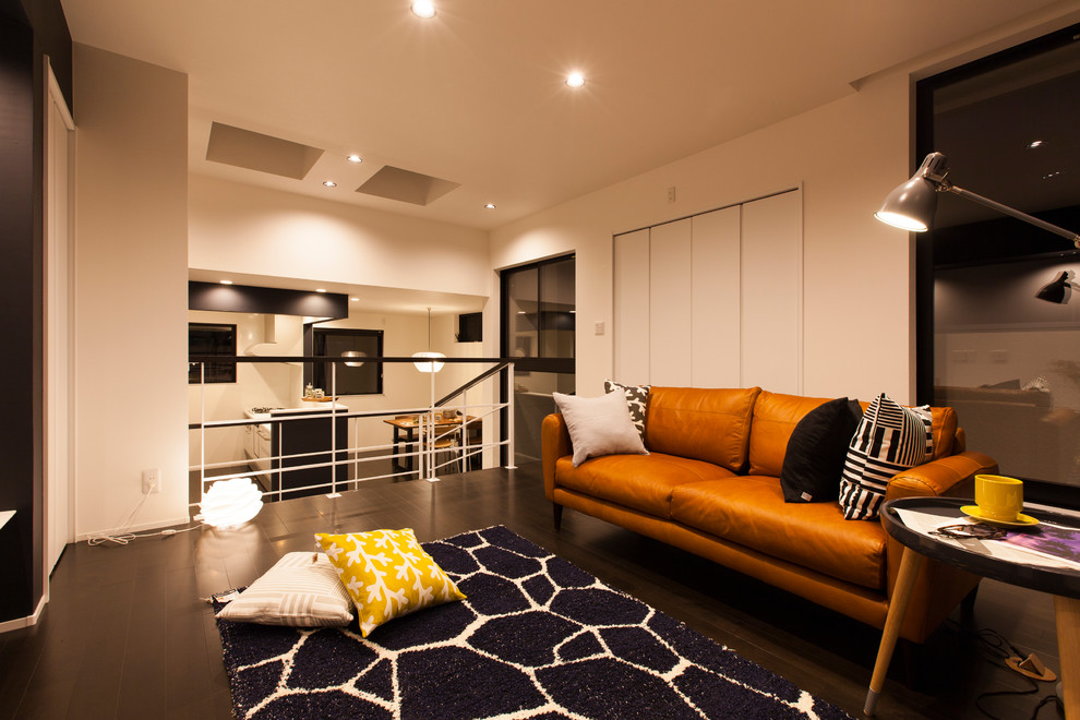 Идея дизайна: маленькая изолированная гостиная комната в стиле ретро с белыми стенами, полом из фанеры, телевизором на стене и черным полом для на участке и в саду