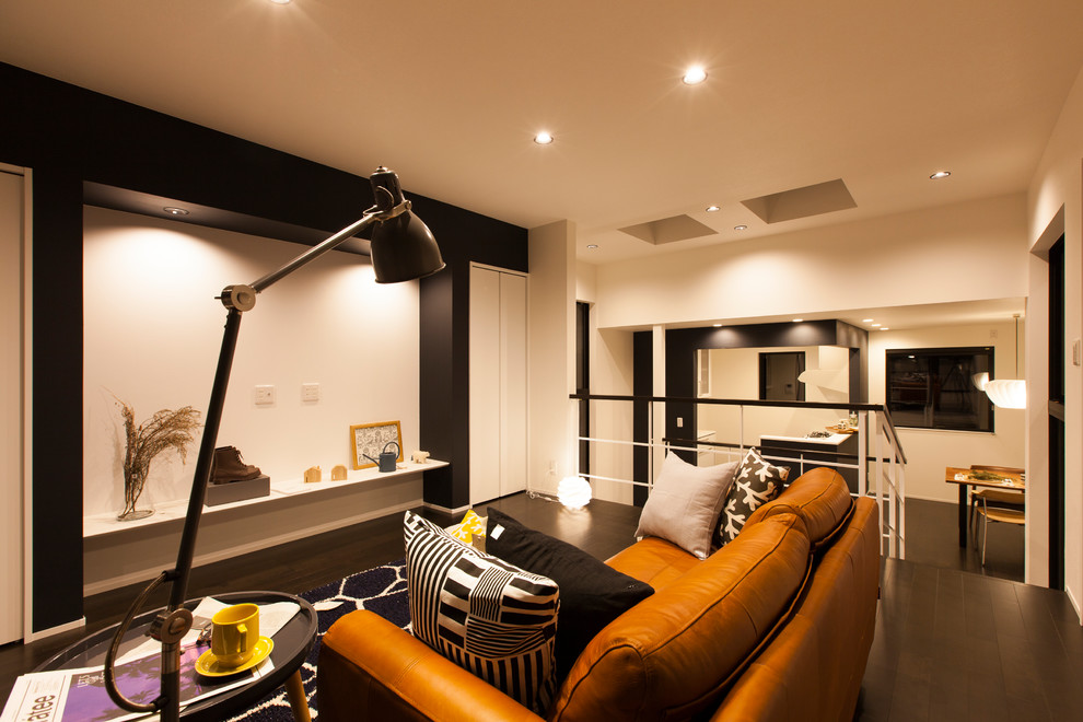 Kleines, Abgetrenntes Retro Wohnzimmer mit weißer Wandfarbe, Sperrholzboden, TV-Wand und schwarzem Boden in Sonstige